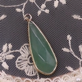 Détail macro du pendentif en pierre verte facettée avec une élégante bordure en métal doré - Aventurine Verte