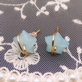 Detailed close-up of blue star gemstone earrings with gold wire wrap on lace background - Amazonite