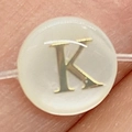 Flat round natural shell bead with golden letter K inlay and horizontal hole - 6mm / Style K