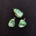 Three irregular green natural shell pendants with gold edges on black background - Green