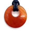 Polished red agate donut pendant necklace with a black braided cord on white background - Red Agate