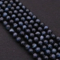 Macro detail of polished blue tiger eye stone beads with natural chatoyant wavy texture - Deep Blue (No.9)