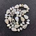 Water-drop shaped white opal beaded necklace with silver lobster clasp on black background - Agate