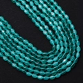 Macro-opname van ovale kattenoogkralen in meergrün met glinsterend effect voor DIY-sieraden - Meer Groen