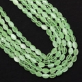 Macro-opname van gefacetteerde ovale lichtgroene kattenoogkralen voor sieraden - 4x6MM