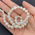 Baroque white freshwater pearls on a string held by hand for jewelry making DIY - 4-5mm / White