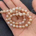 Hand holding natural pink baroque freshwater pearls strand for jewelry making and DIY - 4-5mm / Sunstone