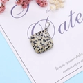 Detail of dalmatian jasper pendant with silver clasp on decorative floral background - Dalmatian Jasper