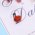 Macro detail of a geometric faceted orange carnelian stone pendant with a silver metal clasp - Red Agate