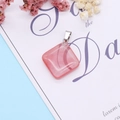 Macro detail of a square pink strawberry crystal pendant with a silver metal bail connector - Watermelon Quartz