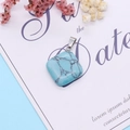 Rhombus turquoise stone pendant with silver clasp on a white decorative card - Blue Turquoise