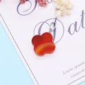 Macro shot of a four-leaf clover pendant made of natural red striped agate gemstone - Red Agate