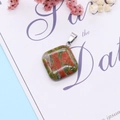 Detailed macro view of Unakite stone square pendant with a polished silver metal clasp - Unakite