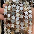 Dettaglio di perline a stella in conchiglia naturale con riflessi per gioielli fai-da-te - Stella / US 6