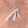 Dettaglio macro di perle barocche naturali in castone a griffe su un gancio in argento - Viola
