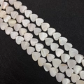 Macro shot of heart-shaped natural shell beads with iridescent luster on black background - Heart / 10mm
