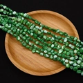 Detail view of 4-6mm green irregular seawater shell beads with pearlescent iris texture - 4-6mm, 27g / Green (No. 11)