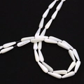 Detalle macro de cuentas de concha blanca en forma de gota con brillo natural de nácar - 4x7mm / Concha Blanca