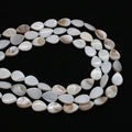 Macro detail of pear-shaped natural mother of pearl beads with soft white luster - Teardrop