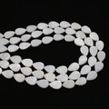 Macro shot of white mother-of-pearl leaf-shaped beads with detailed carvings on black background - Leaf Shape / 10x15mm