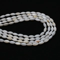 Macro detail of white oval freshwater shell beads with natural luster on black background - Seed Beads