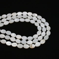 Macro shot of oval white mother of pearl loose beads with natural iridescent luster for DIY - Oval