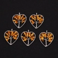 Detail view of five silver wire wrapped heart pendants with orange stone tree of life design - Citrine