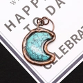 Macro shot of turquoise moon pendant with vintage bronze plating and double ring bail - 4.3cm x 5.5cm / Blue Turquoise
