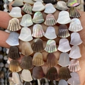 Macro shot of bell-shaped natural mother of pearl beads with fine vertical texture stripes - Scalloped Shape / 10x15