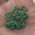 Golden chain jewelry with turquoise beads stacked in palm for size reference - In Roll / Turquoise