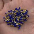 Golden chain with royal blue enamel beads held in hand for size visualization - In Roll / Sapphire Blue