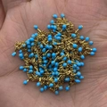 Golden chain with sky blue beads for DIY jewelry making displayed in hand - In Roll / Sky Blue