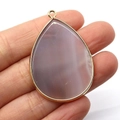 Teardrop grey agate stone pendant with gold bezel held to show size and texture - Grey Agate