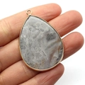 Teardrop grey marble stone pendant with gold metal plating shown in hand for scale - Gray Marble Pattern Stone (No. 8)