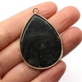 Teardrop pendant with green spotted stone and golden rim held in hand for size - Dark Green Marbled Stone (No. 14)