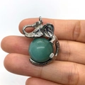 Silver elephant pendant with a round green gemstone held by hand on white background - 21x32mm / Green Aventurine (6)