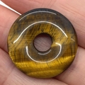 Polished natural tiger eye stone donut pendant featuring unique brown and golden textures - Tiger's Eye