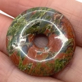 Polished Unakite stone donut pendant with natural green and pink mottled texture - Unakite