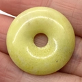 Natural light yellow gemstone donut pendant with organic mineral textures and patterns - Topaz