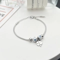 Detaillierte Makroansicht vom silbernen Schlangenarmband mit Kleeblatt und Emailleperlen - Weiße Runde Perlen (Blaue Blume) / Silber (Weiße Perlen Kleeblatt-Stil)