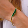 Elegantes goldenes Schlangenarmband mit sieben grün abgestuften Zirkonia-Steinen - 18K-Gold / Smaragdgrüner Strass Armband