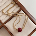 Collier double épaisseur en acier titane doré avec pendentif sphérique rouge foncé - Collier Perles Rouges Double Couche / Or