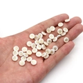 Cuentas redondas de concha blanca con patrón de trébol dorado sostenidas en la mano - Flor de Cuatro Pétalos / 6mm (20 Piezas)
