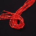 Vue macro de perles en nacre rouge en forme de goutte sur fond noir texturé élégant - 5x8mm / Rouge