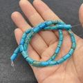 Blue cylindrical emperor stone beads with brown veining held in hand for jewelry DIY - 4x8mm / Sky Blue