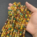 Faceted mixed color natural agate beads for DIY jewelry making held in hand - Yellow Green Agate