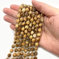 Strands of faceted natural Picture Jasper beads in earthy brown and yellow tones - Picture Jasper