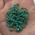 Handheld view of turquoise cylinder stone and golden bead chain for DIY jewelry making - 3x5mm / Turquoise