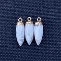 Drie kogelvormige witte turquoise hangers met gouden connectoren op zwarte stof - Howliet