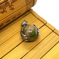 Polished Unakite stone sphere pendant with silver claw setting on bamboo mat - Unakite